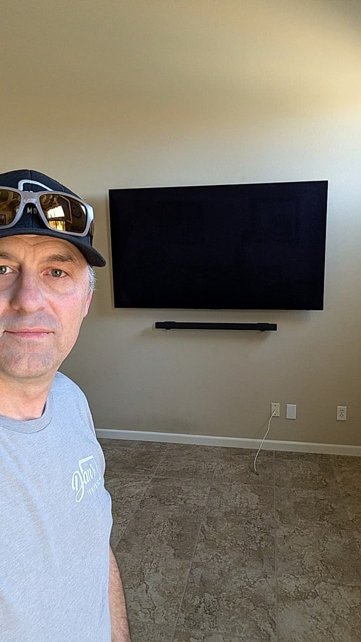 Dan with large TV and wall-mounted soundbar with wires hidden in wall in Roseville, CA