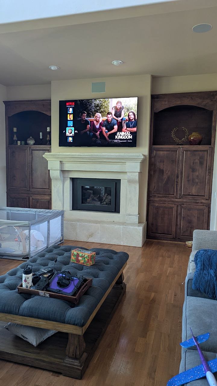 Large TV above stone fireplace with wood built-ins in Granite Bay, CA