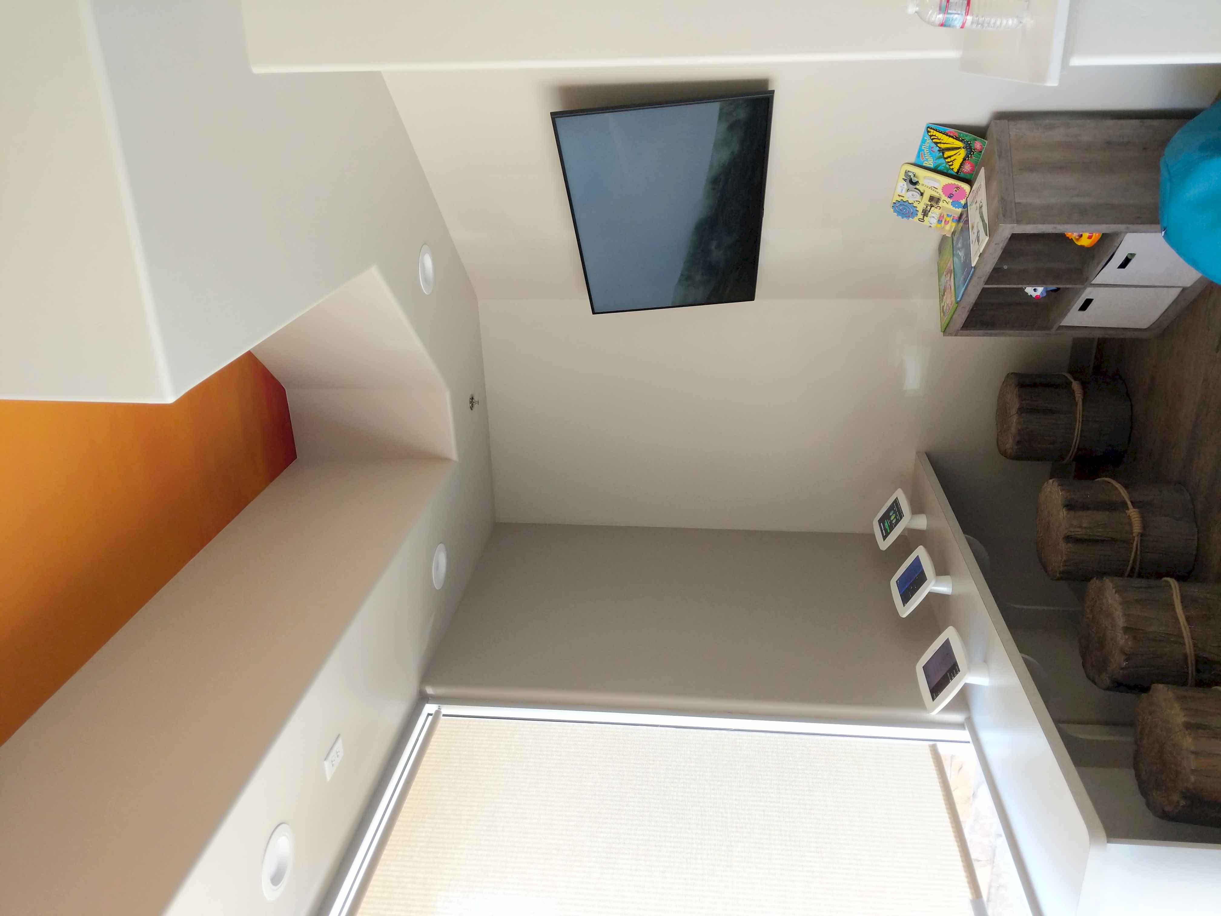 TV mounted in kids room with orange accent wall in Roseville, CA