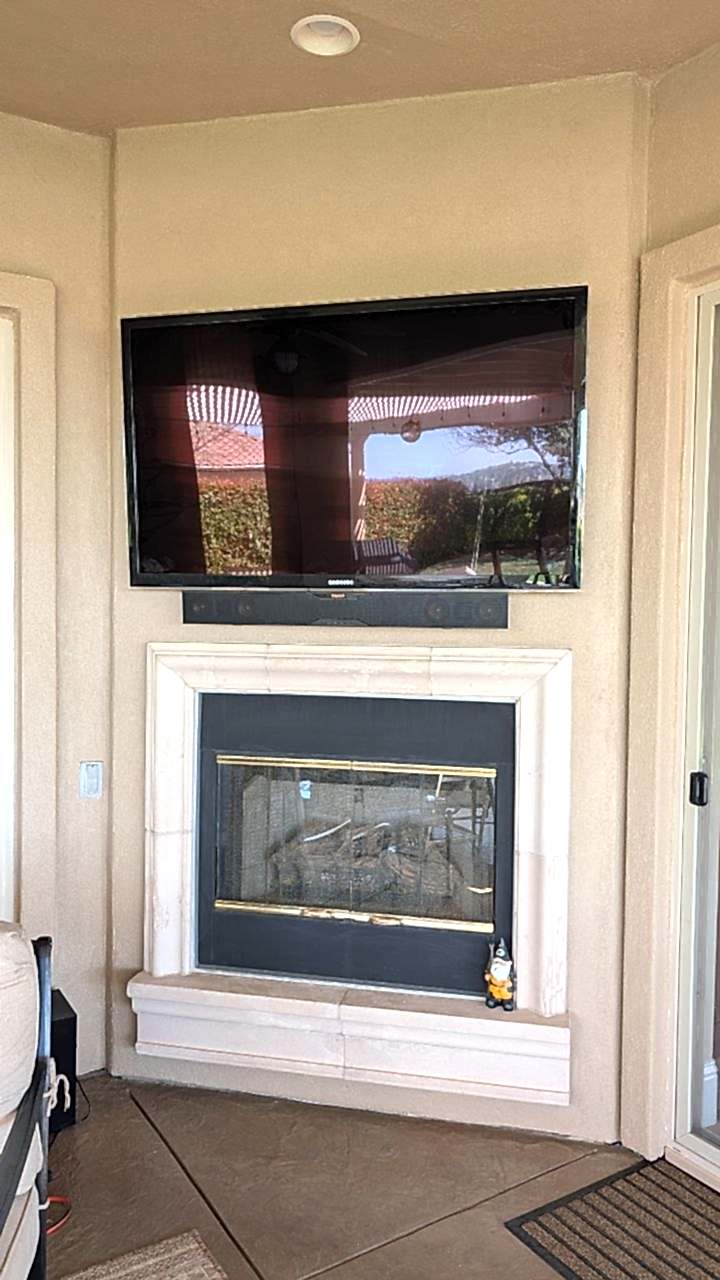 Samsung TV and Klipsch soundbar mounted above stucco fireplace in Folsom, CA